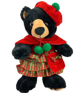 Christmas style dress in red and green with a red cape and a red hat with green pons, small red pouch on a black bear